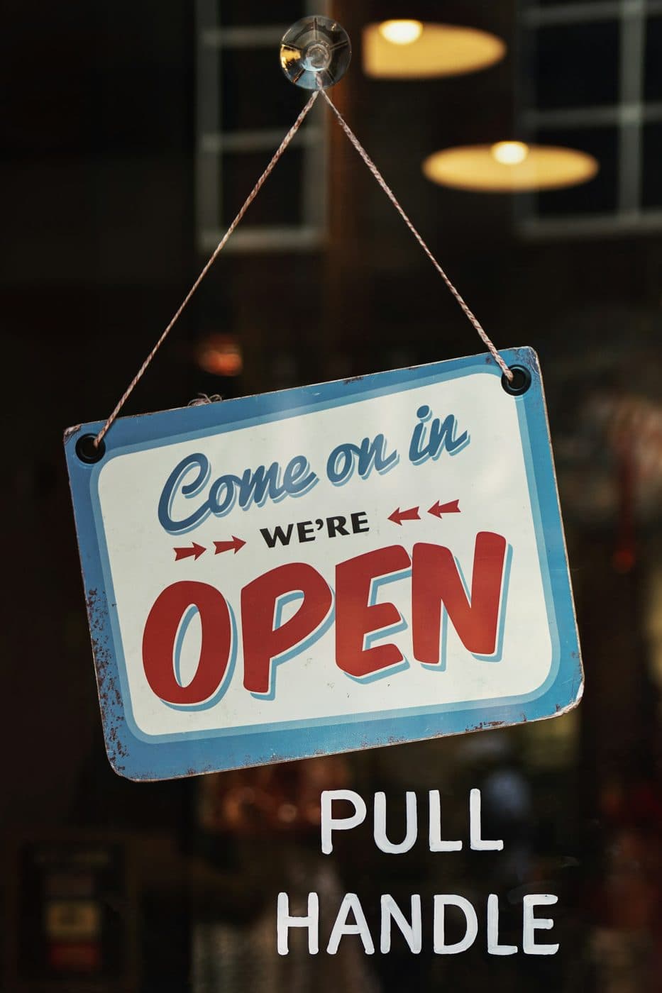 Pancarte « ouvert » accrochée à la porte d’une boutique